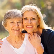smiling senior woman and middle aged daughter outdoors closeup p