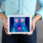 Man with tablet in hands. Urinary system on screen. Urology concept.